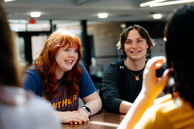 Students talking at a table in Schindler