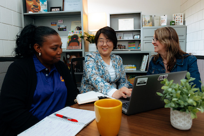 UNI staff members sitting around a table